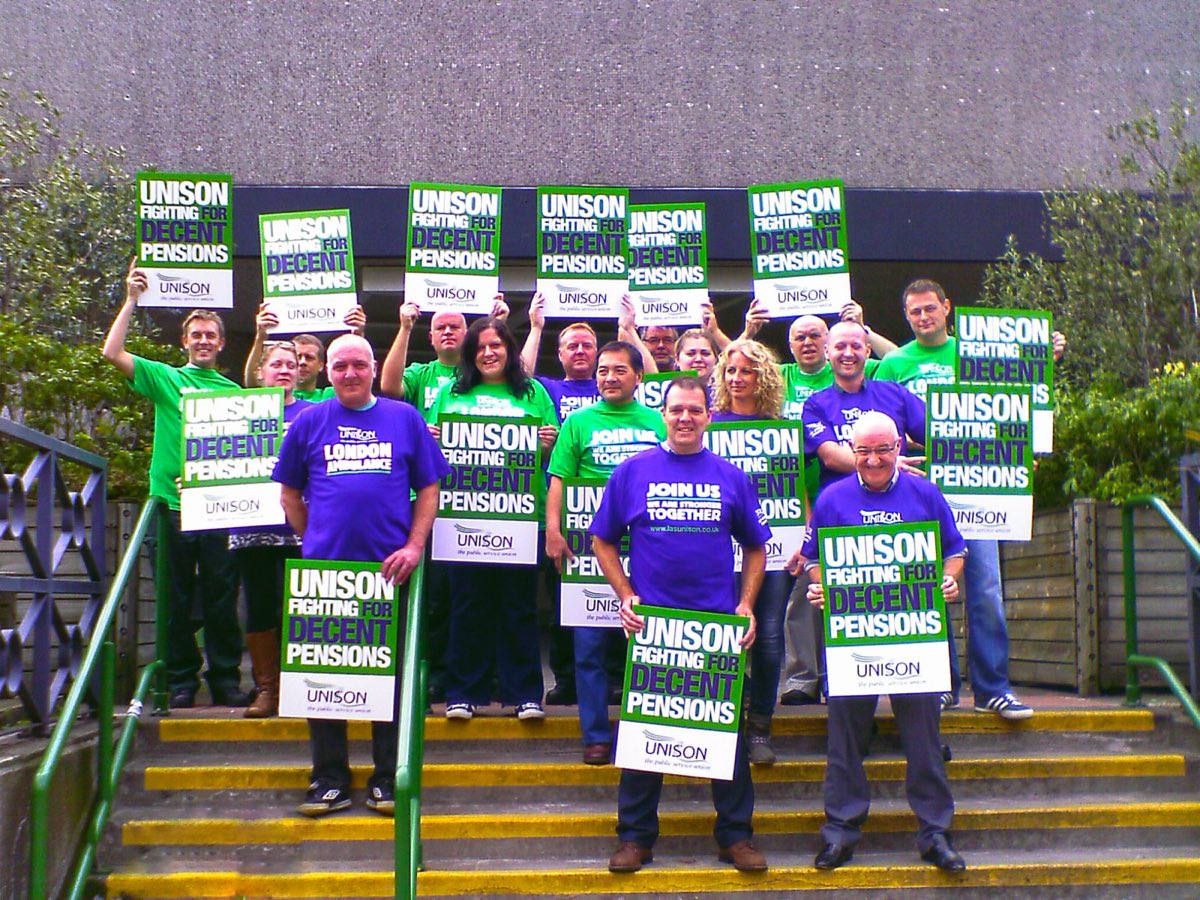 London Ambulance Service UNISON members standing together on the steps holding branch placards.